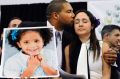 Jimmy Greene, left, kisses his wife Nelba Marquez-Greene while holding a portrait of their daughter, Sandy Hook ...