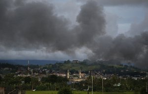 In this June 9 photo, black smoke from continuing military air strikes rises above a mosque in Marawi city, southern Philippines Friday, June 9, 2017. Nearly every day for the past three weeks, the Philippine military has pounded the lakeside town of Marawi with rockets and bombs as it tries to wipe out militants linked to the Islamic State group in some of the most protracted urban combat to hit this volatile region in decades. (AP Photo/Aaron Favila)