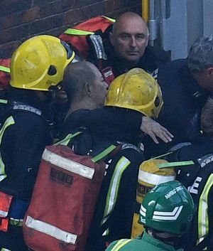 LONDON, ENGLAND - JUNE 14: A man is rescued by fire fighters after a huge fire engulfed the 24 storey residential ...