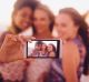 Mixed racial group of friends taking a selfie at the beach on their phone