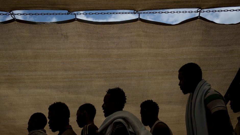 Refugees and migrants wait to disembark the Migrant Offshore Aid Station (MOAS) Phoenix vessel after arriving at Reggio ...