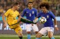 Under pressure: Socceroo James Troisi tries to get a kick away from Brazil’s David Luiz.