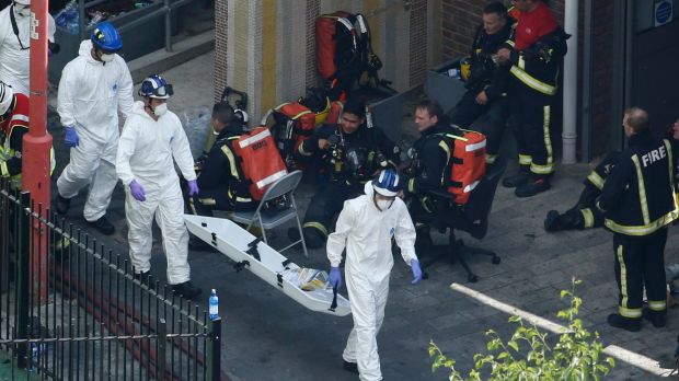 Rescue crews carry stretchers towards the gutted building.