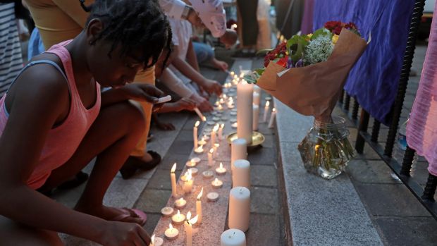 People pray and candles are lit outside Notting Hill Methodist Church near the 24 storey residential Grenfell Tower block.