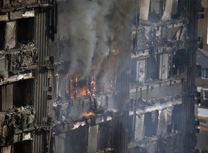 Parts of the building still burn hours after a deadly blaze at a high rise apartment block in London, Wednesday, June 14, 2017.