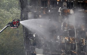 A remote firefighting platform continue to damp-down the deadly fire at Grenfell Tower in London, Thursday, June 15, 2017.