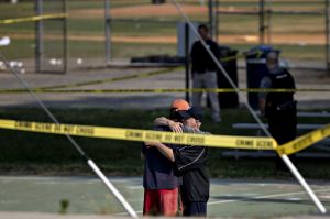 Two people hug in front of police tape following a shooting during a congressional baseball practice near the Eugene ...