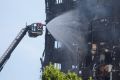 Firefighters working to put out the last embers of the fire which devastated Grenfell Tower.