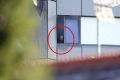 A man looks from a window of Grenfell Tower, as a fire burns three floors above him.