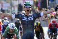 Austria's Lukas Poestelberger celebrates as he crosses the finish line to win the first stage of the Giro d'Italia.