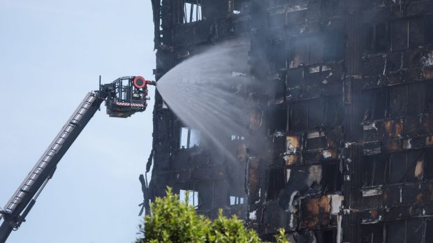 Firefighters working to put out the last embers of the fire which devastated Grenfell Tower.