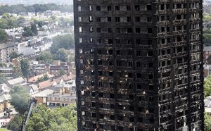 Firemen examine the scorched facade of the Grenfell Tower in London on a huge ladder, Thursday, June 15, 2017.