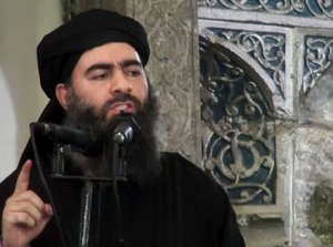 This file image made from video posted on a militant website Saturday, July 5, 2014, purports to show the leader of the Islamic State group, Abu Bakr al-Baghdadi, delivering a sermon at a mosque in Iraq during his first public appearance.