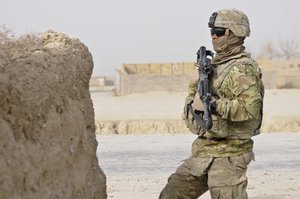 Specialist Hamilton Ciramagua with Troop O (Outlaw), 4th Squadron, Combined Task Force Dragoon, occupies a security position during a partnership patrol with members of the Afghan Uniformed Police Dec. 30, 2013, at Kandahar Province, Afghanistan