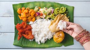 Indian woman eating banana leaf rice, overhead view on wooden dining table. SatJun17cover-WorldFood - Ben Groundwater ...