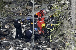 Emergency workers search debris that fell at the base of the fire-gutted Grenfell Tower in London, Friday, June 16, 2017, after a fire engulfed the 24-story building Wednesday morning.