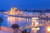 Panoramic view of the Hungarian Parliament Building and the Szechenyi Chain Bridge in Budapest at dusk.