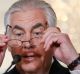 Secretary of State Rex Tillerson puts on his glasses before reading a statement about Qatar at the State Department in ...