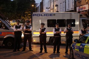 Emergency services stand guard on Fonthill road near Finsbury Park station after a vehicle struck pedestrians in north London, Monday June 19, 2017.