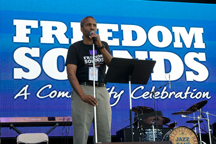 Program co-curator Mark Puryear announces the next act on the Freedom Sounds Stage.