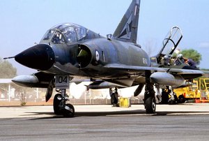 A Royal Australian Air Force (RAAF) Squadron 77 Mirage III-D aircraft taxis on the flight line while another Mirage is serviced. The jets are taking part in PITCH BLACK '88, a joint Australia-US Exercise emphasizing night flying. 		 		%lt;table