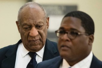 A closeup of Bill Cosby with his eyes down next to spokesperson Andrew Wyatt.