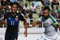 Japan's Yuya Kubo, left, and Iraq's Waleed Salim Al-Lami compete for the ball. 