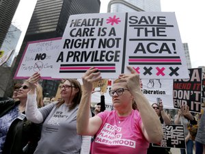 File - Protesters gather across the Chicago River from Trump Tower to rally against the repeal of the Affordable Care Act Friday, March 24, 2017, in Chicago.