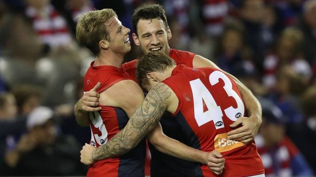 Good spirits: Mitch Hannan celebrates with teammates as Melbourne move up to fifth on the AFL ladder.