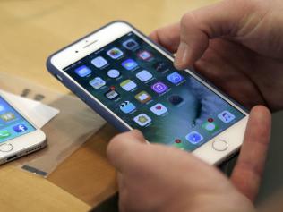 FILE - In this Friday, Sept. 16, 2016, file photo, a customer sets up his new iPhone 7 Plus, right, as he switches from the iPhone 6 at the Apple Store on Michigan Avenue during the release of the Apple iPhone 7 and the latest Apple Watches, in Chicago. Apple is intensifying its legal battle with Qualcomm over the technology in iPhones and iPads as Apple seeks to void some of the chip makerâ€™s patent claims and licensing agreements. Qualcomm has disputed Appleâ€™s claims that Qualcomm is overcharging for patent-related license fees on iPhone and iPad sales. Apple says that a recent Supreme Court ruling strengthens its argument that Qualcomm cannot continue to demand royalties for patents after selling its cellular chips. (AP Photo/Kiichiro Sato, File)