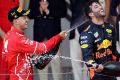 Ferrari's race winner Sebastian Vettel sprays Red Bull's Daniel Ricciardo, who finished third at the Monaco Grand Prix ...