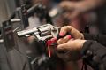 A woman handles a gun at the National Rifle Association annual show in Nashville in 2015.