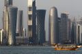 FILE - In this Thursday Jan. 6, 2011 file photo, a traditional dhow floats in the Corniche Bay of Doha, Qatar, with tall ...