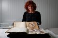 Julie Ryder holds the Port Phillip seaweed album, with the Port Arthur album in the foreground.