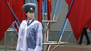 A North Korean traffic police woman stands in front of Workers' Party flags decorating the streets in Pyongyang. 