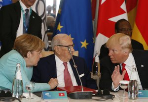 File - U.S. President Donald Trump, right, and German Chancellor Angela Merkel, left, speak with Tunisian President Beji Caid Essebsi as they attend a round table meeting of G7 leaders and Outreach partners at the Hotel San Domenico during a G7 summit in Taormina, Italy, Saturday, May 27, 2017.