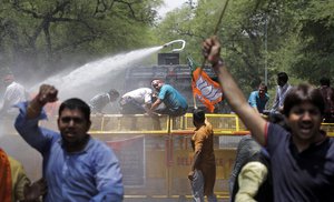 File - Policemen use water canon to disperse activists of the youth wing of India's ruling party Bharatiya Janata Party during a protest against the slaughter of a calf by Congress party's youth wing members in the southern Indian state of Kerala as an act of protest against the ban of sale of cows and buffaloes for slaughter, outside the Congress party headquarters in New Delhi, India, Tuesday, May 30, 2017.