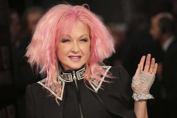 FILE - In this April 3, 2016 file photo, actress and singer Cyndi Lauper poses for photographers upon arrival at the Olivier Awards in London. “Working Girl,” the story of a secretary who breaks out of the typing pool, is heading to the stage as a musical and Lauper will be writing the songs. A production timeline will be announced at a later date. (Photo by Joel Ryan/Invision/AP, File)