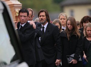 Actor Jim Carrey, centre, joins mourners behind the coffin of his ex-girlfriend Cathriona White as they walk to Our Lady of Fatima Church, in her home village of Cappawhite, Co Tipperary, Ireland, ahead of her funeral, Saturday Oct. 10, 2015.