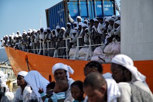 File - As some migrants already disembarked the 'Aquarius' vessel, others are still waiting to leave the ship in Messina, Italy, Sunday, June 26, 2016.