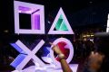 An attendee points past a Sony Corp. PlayStation logo before a Sony event ahead of the E3 Electronic Entertainment Expo ...