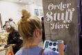 A customer uses a tablet computer to place an order at the new Whole Foods Market in Los Angeles.