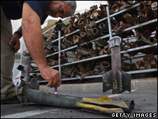 An Israeli policeman writes the date and place of impact on a Qassam rocket shortly after it struck a house in Sderot (file photo)