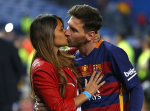 Barcelona's Lionel Messi kisses his wife Antonella Roccuzzo as they celebrate after winning the final of the Copa del Rey soccer match between FC Barcelona and Sevilla FC at the Vicente Calderon stadium in Madrid