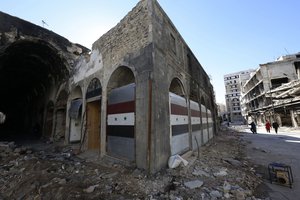 File - Damaged shops are seen with new doors in the old city of Homs, Syria on Tuesday, Dec. 8, 2015.