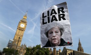 File - Demonstrators hold a banner as they protest near parliament in London Wednesday June 21, 2017. The mass 'Day of Rage' demonstration is timed to coincide with the state opening of parliament Wednesday.