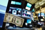 A stock trader has taped a one dollar bill to his computer screen at the New York Stock Exchange - U.S. stocks are lower Thursday morning as health care companies take more losses