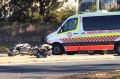 Two ambulances were on the scene of a crash between a truck and a motorcycle in Queanbeyan.