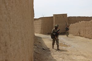 File - U.S., Georgian and Afghan army soldiers patrol outside of the Qaleh Musa Pain village in Helmand province, Afghanistan, March 12, 2015.