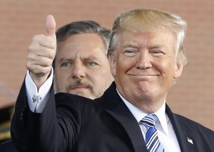 President Donald Trump, right, gives a thumbs up as Liberty University president, Jerry Falwell Jr., left, watches during of commencement ceremonies at the school in Lynchburg, Va., Saturday, May 13, 2017.